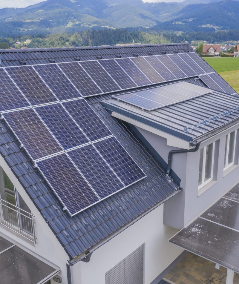 High angle shot of a private house situated in a valley with solar panels on the roof A high angle shot of a private house situated in a valley with solar panels on the roof